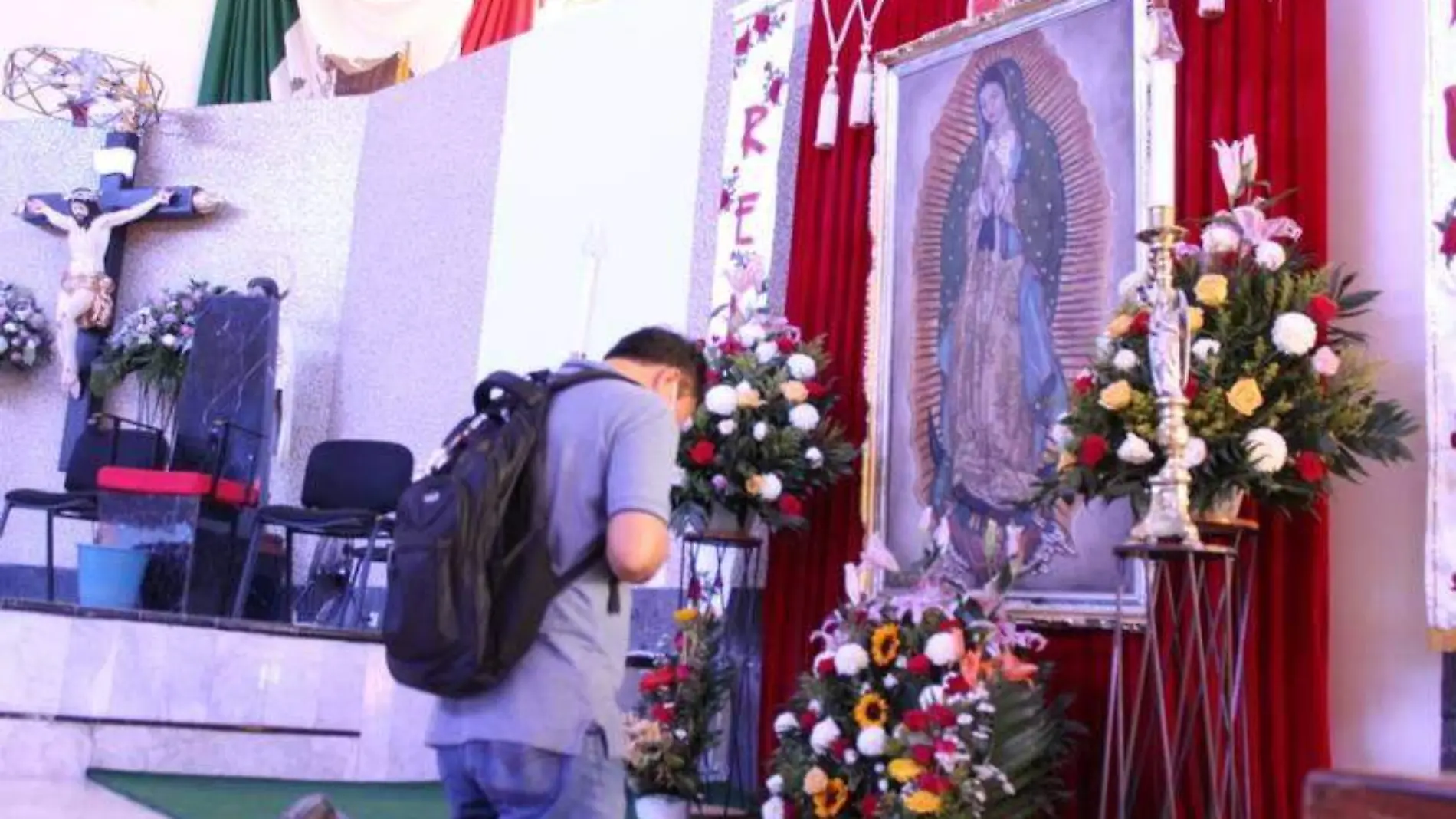 Hombre hincado frente a la imagen de la Virgen de Guadalupe